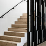 Minimalist interior featuring white-stained wood flooring.